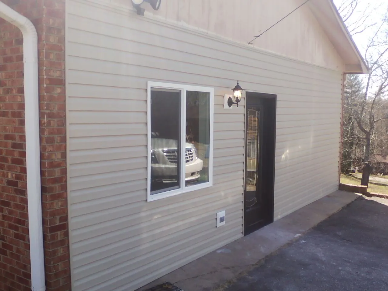 New vinyl siding and entry door on a room addition in Davenport
